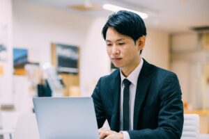 ノートパソコンで購買シグナルを確認するビジネスマン